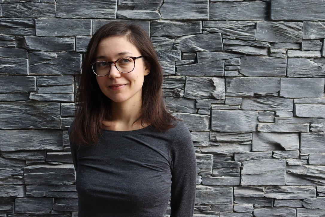 Photo de Juliette devant un mur de briques grises